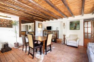 uma sala de estar com uma mesa de madeira e cadeiras em Quinta Alegre em Porches