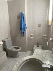 a bathroom with a toilet and a blue towel on the wall at 1era linea de playa Cullera Villa Sales in Cullera