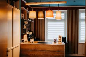 a kitchen with a counter with a window and lights at Hotel Garni "Villa am Schaalsee" in Zarrentin