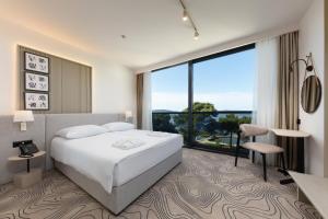 a hotel room with a bed and a large window at SeeSea Hotel in Vodice