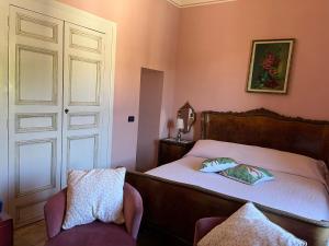 1 dormitorio con 1 cama, 1 silla y 1 puerta en Palazzo Cutrufelli, en Graniti