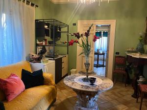 un soggiorno con divano e tavolo con fiori di Palazzo Cutrufelli a Graniti