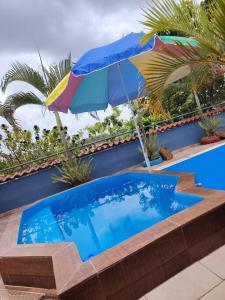 una piscina azul con sombrilla y sombrilla en Casa con piscina, 1 cuarto barato, en ArraijÃ¡n