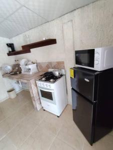 a kitchen with a black and white stove and a refrigerator at Casa con piscina, 1 cuarto barato in ArraijÃ¡n