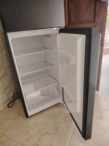 an empty refrigerator with its door open in a kitchen at Casa con piscina, 1 cuarto barato in ArraijÃ¡n