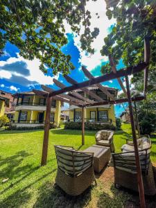 a pergola and two chairs in a yard at Pousada Pontal da Praia in São Pedro da Aldeia