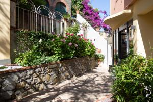 a street in a town with flowers on a wall at The Time -Home & Hotel- in Santa Margherita Ligure