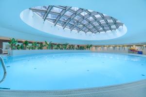a large swimming pool with a glass ceiling at Margi Velvet Apartament 13TH FLOOR LED CEILING BATH POOL in Szczecin
