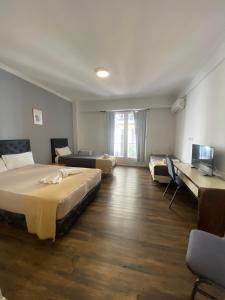 a hotel room with a bed and a couch and a bed at Hotel Chacabuco in Buenos Aires