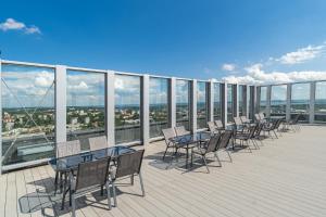 a balcony with tables and chairs on a building at Margi Velvet Apartament 13TH FLOOR LED CEILING BATH POOL in Szczecin