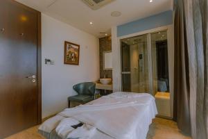 a bedroom with a bed and a chair and a bathroom at Crowne Plaza Nairobi Airport by IHG in Nairobi