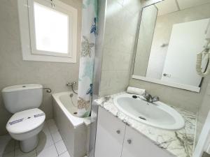 a bathroom with a toilet and a sink and a mirror at Sol y Mar Segur in Segur de Calafell