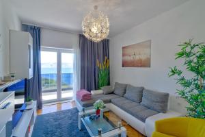 ein Wohnzimmer mit einem Sofa und einem Kronleuchter in der Unterkunft Apartments Maria in Senj
