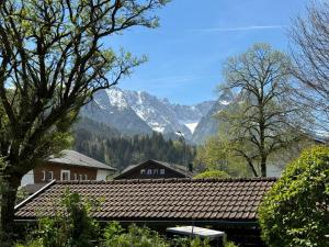 een huis met een dak met bergen op de achtergrond bij Ferienwohnung Gary mit zwei Terrassen und Garten in Garmisch-Partenkirchen