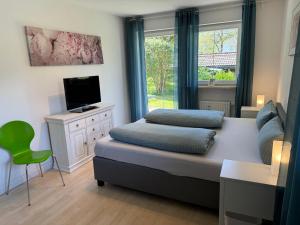een slaapkamer met een bed, een tv en een raam bij Ferienwohnung Gary mit zwei Terrassen und Garten in Garmisch-Partenkirchen