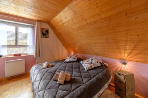 duże łóżko w pokoju z drewnianym sufitem w obiekcie Gîte en montagne vosges alsaciennes w mieście Fréland