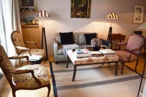 a living room with a couch and a table and chairs at La Défense - Paris in Neuilly-sur-Seine