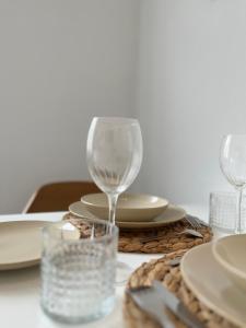 una mesa con dos copas de vino y platos en ella en Traumhaftes City Apartment en Viersen