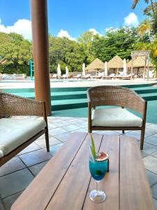 a wooden table with a drink on top of a table at La Kawanaise Blue Lagon in Grand-Bourg