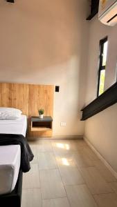 a bedroom with two beds and a plant on a table at Seven hotel in Santa Fe de Antioquia