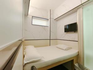 een kleine kamer met een bank en een tv bij i-Hostel (Cameron Road) in Hong Kong