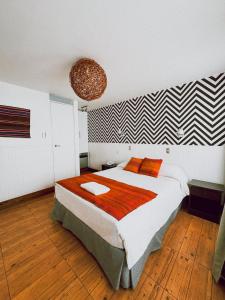 a bedroom with a large bed with orange pillows at Hotel Avenida en Arica in Arica