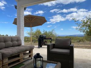 a patio with two chairs and an umbrella and a grill at Casa the Dutchman in Navarrés