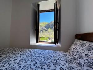 a bedroom with a bed and an open window at La Casa de la Abuela Concha in Felmín
