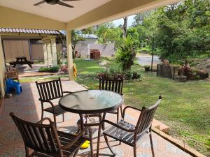 a patio with a table and chairs and a yard at Teratak D Tuntung in Kampong Mesjid