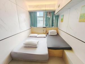 een kleine kamer met 2 bedden en een raam bij i-Hostel (Cameron Road) in Hong Kong