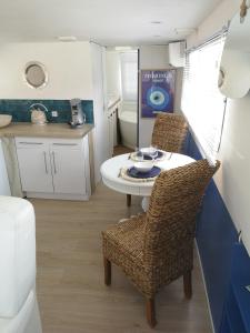 uma pequena cozinha com uma mesa e cadeiras numa caravana em Bateau Mama Mia em Narbona