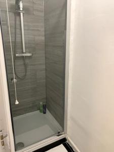a shower with a glass door in a bathroom at Warren Street Guest House in London
