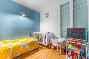 een slaapkamer met een bed, een tafel en een schoolbord bij Appartement cosy à 5min de Paris in Saint-Mandé