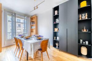 een eetkamer met een witte tafel en stoelen bij Appartement cosy à 5min de Paris in Saint-Mandé