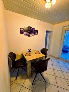 - une salle à manger avec une table et des chaises en bois dans l'établissement B&R Ferienhaus In der Nähe des Flughafens, à Nuremberg