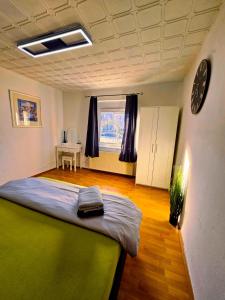 um quarto com uma cama e um relógio na parede em B&R Ferienhaus In der Nähe des Flughafens em Nurembergue