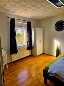 um quarto com uma cama, uma janela e um relógio em B&R Ferienhaus In der Nähe des Flughafens em Nuremberga