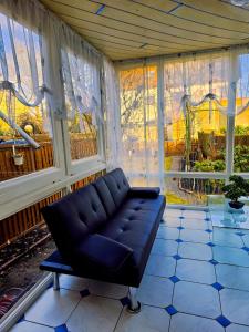 uma sala de estar com um sofá em frente às janelas em B&R Ferienhaus In der Nähe des Flughafens em Nuremberga