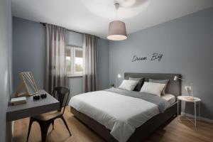 a bedroom with a bed and a desk with a sign on the wall at Villa Fabiana, a luxurious and spacious villa, few minutes from the beach in Labin +21 photos