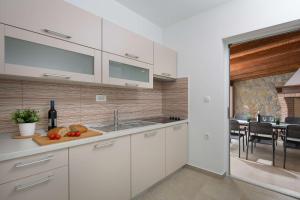 a kitchen with white cabinets and a sink and a table at Villa Fabiana, a luxurious and spacious villa, few minutes from the beach in Labin