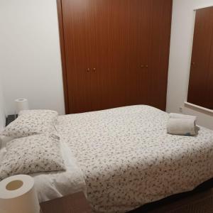 a bedroom with a bed with white sheets and pillows at Casa Familiar Porto in Porto