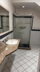 a bathroom with a sink and a glass shower at Cantinho do Sossego in Rio de Janeiro