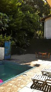 a swimming pool with chairs and a table in a yard at Cantinho do Sossego in Rio de Janeiro