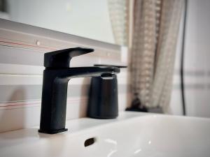 een zwarte kraan op een wastafel in een badkamer bij Seaview Apartment in Empuriabrava