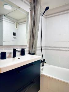 een badkamer met een wastafel, een spiegel en een bad bij Seaview Apartment in Empuriabrava