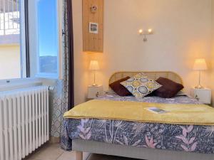 a bedroom with a bed with two lamps and a window at Atypique Détour in Rosans