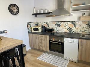a kitchen with a stove and a microwave at BULEVAR SUITE in Nava de la Asunción