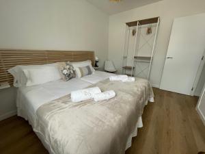 1 dormitorio con 1 cama grande y toallas. en BULEVAR SUITE, en Nava de la Asunción