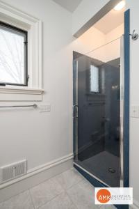 a glass shower in a bathroom with a window at Haven on Howard in Grand Haven