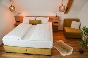 Gasthof zum Ritter - a cozy historical Landmark في أولم: غرفة نوم بسرير كبير وكرسي